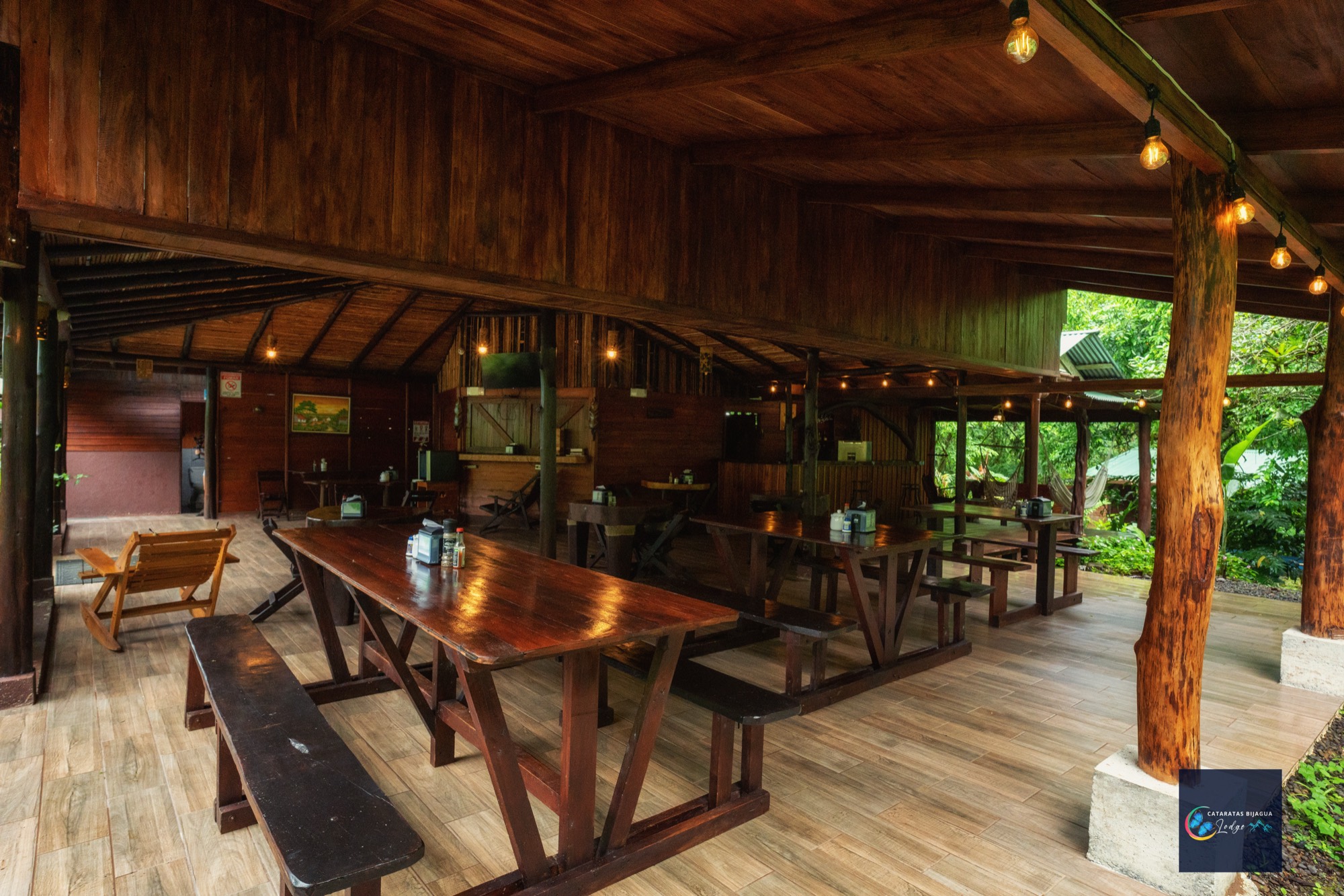 Comedor abierto del lodge, con mesas largas de madera