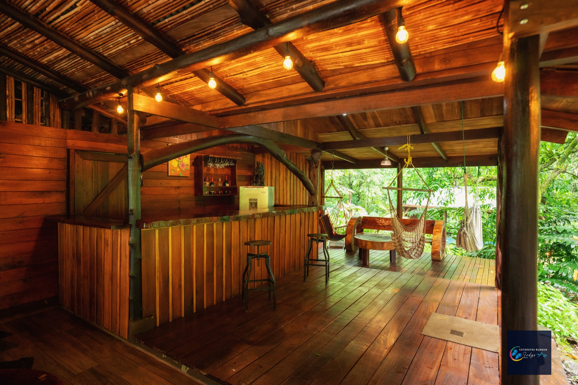 Barra de madera del lodge con hamacas frente al bosque